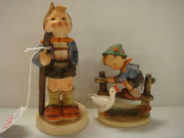 Barnyard Hero and Little Hiker Hummels: 176A Barnyard Hero and Little Hiker Hummels: Barnyard Hero is 195 2/0, TMK 2 Mark, 4"T. Little Hiker is 16/1 Full Bee Mark, Chip Under Hair, 6"T (150-250)