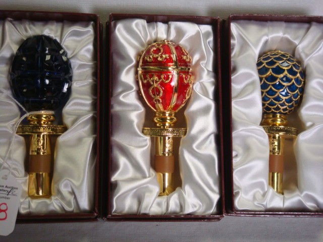 Three TATIANA FABERGE Egg Wine Bottle Stoppers: Three TATIANA FABERGE Egg Wine Bottle Stoppers: Boxes are Signed. Styled After Russian Imperial Eggs. Accented with 24KT Gold Plate. Expandable Adjustable Bottle Topper, Fits Any Size Bottle with Airt