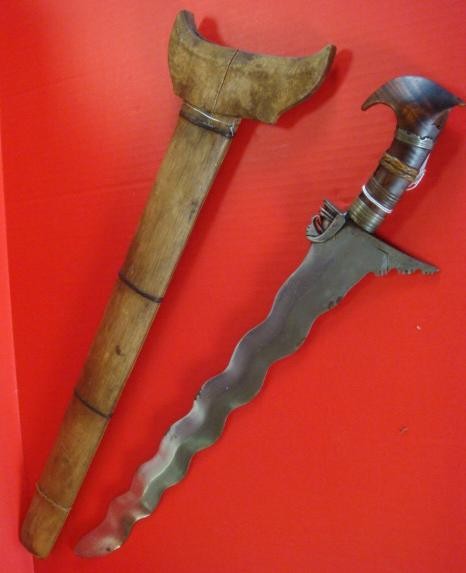 Moro Kris Sword with Wooden Handle & Scabbard: Moro Kris Sword with Wooden Handle & Scabbard: 19 1/2" Traditional Wavy Blade with Parrot's Beak Hilt. Mahogany Handle with Rattan and Metal Wraps. 23 1/2" LOA with Wooden Shaped Scabbard. Brought Bac