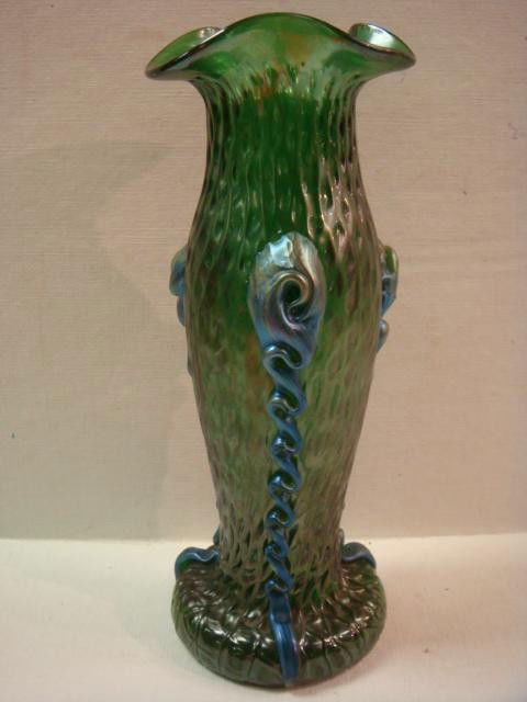 LOETZ Iridized Green Vase with Applied Rigaree: LOETZ Iridized Green Vase with Applied Rigaree: Folded Rim Top with Textured Body to Round Foot. Applied Blue Rigaree. 9"T. (500-900)