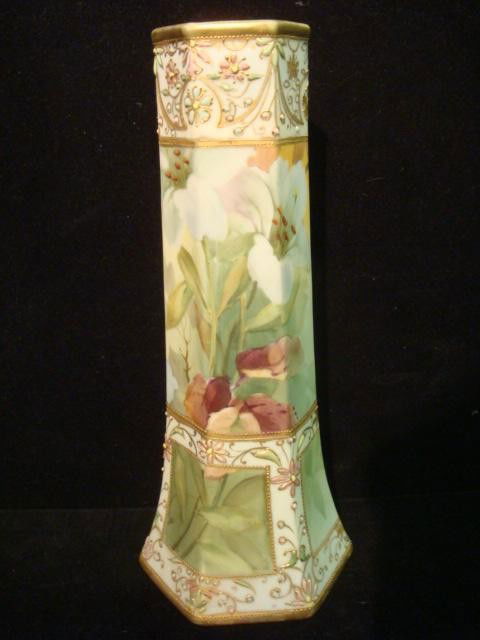 Handpainted Nippon Paneled Vase: Handpainted Nippon Paneled Vase: Hexagonal Vase has Green M in Wreath Mark of Morimura Brothers Japan. Handpainted Lilies and Enameled Floral and Moriage Trim. Gold Accents. 10 1/4"T. (100-180)