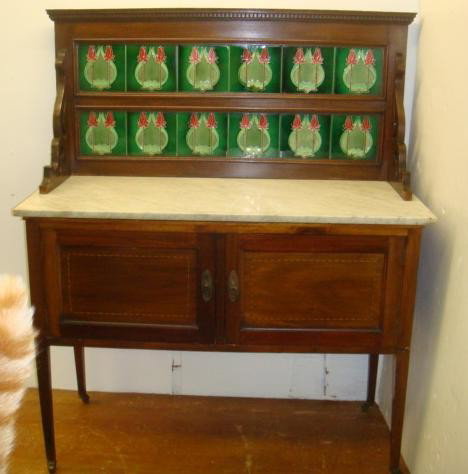 Inlaid Victorian Wash Stand with Tulip Tile Backspl: Inlaid Victorian Wash Stand with Tulip Tile Backsplash Dentil Molded Crest Over 2 Rows of Ceramic Tiles having Tulip Design. White Marble Over Double Paneled Cabinet. Square Tapered Legs on Castors. O