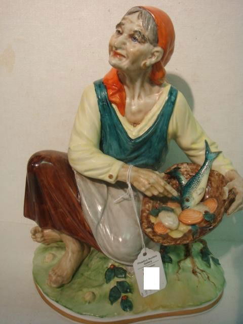 SANDIZELL PORCELAIN FACTORY Gypsy Woman Figurine: SANDIZELL PORCELAIN FACTORY Gypsy Woman Figurine: German Factory Still in Production 1951-Today. Crowned N Mark Dresden. Gypsy Woman with Basket of Fish and Clams. 10 3/4"T (180-300)