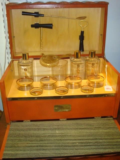 ANCHOR HOCKING Traveling Bar with Bar Tools: ANCHOR HOCKING Traveling Bar with Bar Tools: 4 Highball, 3 Shot Glasses, 3 Whiskey Bottles, Spoon, 2 Openers, Strainer and Shaker. Chain Hinge Lid, Fitted Wooden Case Resembling Collection of Books. M