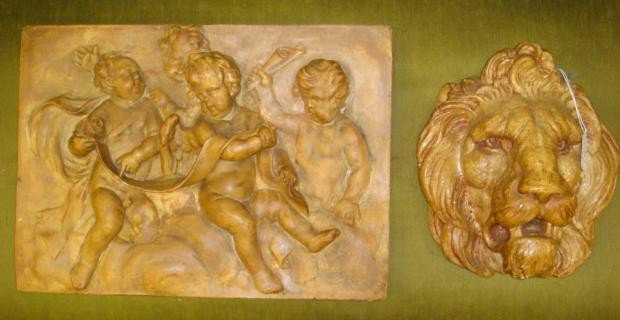 Plaster Lion's Head and Putti Relief Plaques: Plaster Lion's Head and Putti Relief Plaques: Lion's Head is 10"T, 9 1/2"W, 6"D. Putti Plaque is 12" X 16 1/2". Repaired. (40-60)