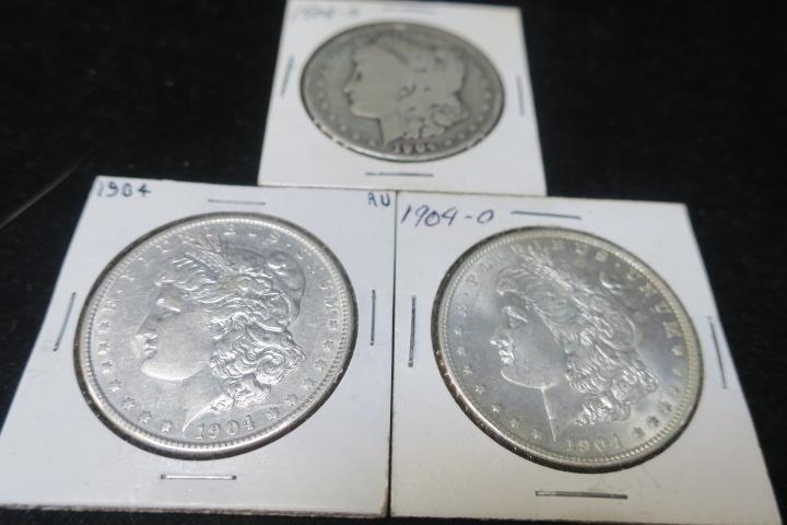 Three 1904 MORGAN SILVER DOLLARS:: Three 1904 MORGAN SILVER DOLLARS: 1904 Morgan Silver dollar in AU 50 condition, 1904 S in VF 20 Condition and 1904 O in MS 63 Condition. (400-600)