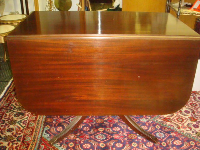 Two Drawer BRANDT Mahogany Drop Leaf Dining Table: Two Drawer BRANDT Mahogany Drop Leaf Dining Table: Drawer at Each End with Brass Pulls. Turned Pedestal Splay Line Carved Legs. 29"T, 22" X 40"T, 19" Drop. (200-350)