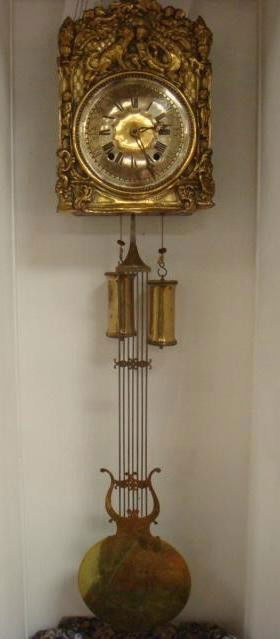 GRAND MORBIER French Comtoise Brass Wall Clock: GRAND MORBIER French Comtoise Brass Wall Clock: Brass Dial with Roman Numerals. Detailed Brass Surround of Dog and Cherubs, Large Brass Pendulum. Handmade and Finished by Hand. Double Weight, Key. Pen