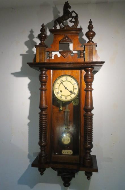 JUNGHANS Antique Regulator Wall Clock:: JUNGHANS Antique Regulator Wall Clock: Walnut Case with Roman Numerals and Brass Escutcheon Around Face and Brass Pendulum. 1/2 Ring Turned Side Columns at Corners of Glass Door Under a Detachable Hor