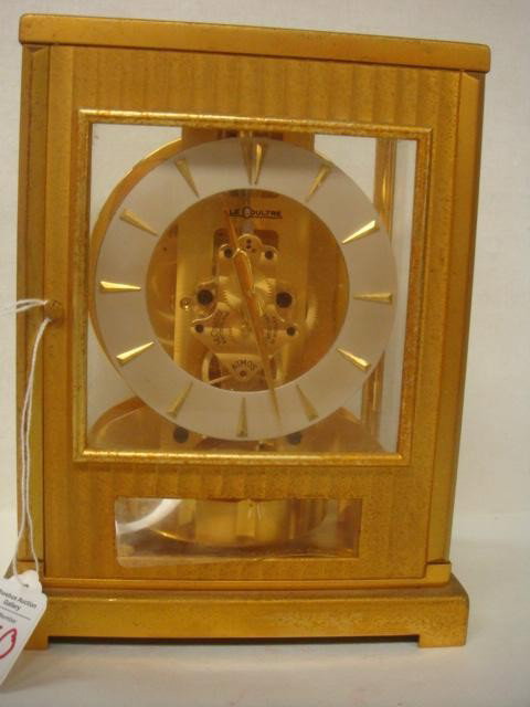 LeCOULTRE ATMOS Perpetual Motion Clock:: LeCOULTRE ATMOS Perpetual Motion Clock: Clock in Gilt and Glass Case has 15 VXN Jewels. 9"T. Glass on Door Under Face is Missing. (300-500)