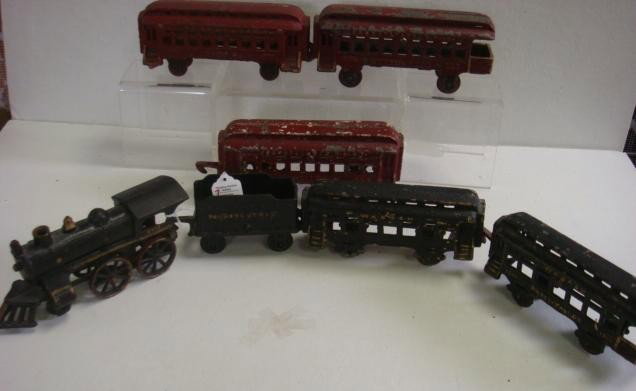 Seven Cast Iron Vintage Toy Rail Road Trains:: Seven Cast Iron Vintage Toy Rail Road Trains: Engine #5490, with Tender and 2 Cars Marked Wabash and PA. 3 Red Passenger Cars #333, Marked Normandie. Engine is 7 1/2"L. (100-200)