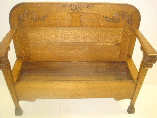 Golden Oak Hall Bench with Hinged Seat:: Golden Oak Hall Bench with Hinged Seat: Round Shoulders at Back. Applied Foliate Carving. Open Paddle Arms. Hinged Lift Top Storage Compartment. Modified Carved Paw Feet. 41"T, 48"W X 18"D. 1900-1920.