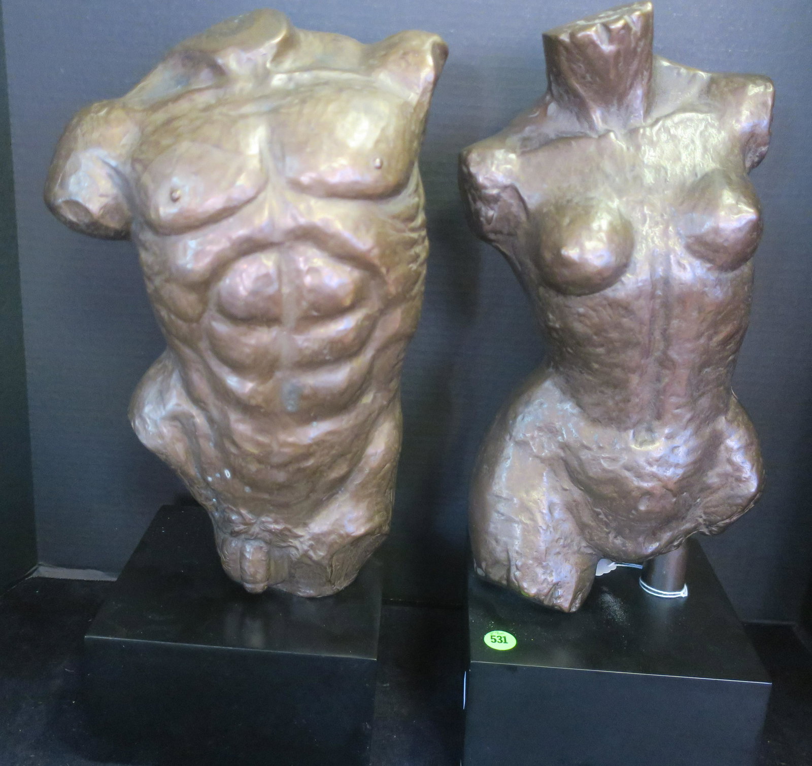 Pair of Nude Female and Male Torso Statues:: Pair of Nude Female and Male Torso Statues: Depicting the Idealized Male and Female Forms. Woman is 14 1/2" Tall on 3 1/2" Black Plinth, with Maker's Mark on Back. Male Torso is 1/4" Tall on 3 3/4" Bl