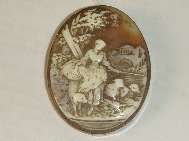 Victorian Shell Carved Pictorial Cameo in Brooch:: Victorian Shell Carved Pictorial Cameo in Brooch: 1 3/4" X 1 1/2" Scenic Oval Cameo Depicting Lady Harvesting with Sheep and Dogs by Her Side; Castle in Background. Set in Wide Rolled Gold Frame with 