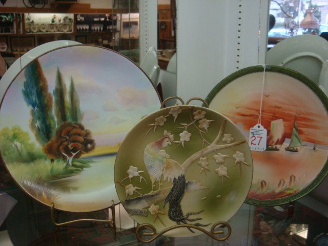 Three Hand Painted NIPPON Porcelain Plaques:: Three Hand Painted NIPPON Porcelain Plaques: 7 1/4"D Unmarked Plaque with Raised Slip Rooster and Plum Tree. 9"D Plaque with Boats and Windmill, Maple Leaf Mark. 10 1/4"D Landscape Plaque With Green M