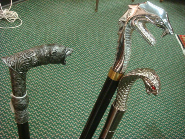 Three Silvertone and Ebony Walking Sticks: Three Silvertone and Ebony Walking Sticks: Each Head Unscrews to Expose Short Sword. Dragon, Cobra and Growling Bear Handles. Rubber Tips on 2. 34" to 39" Long. (60-120)