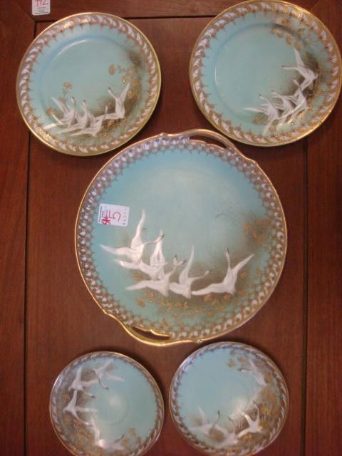 Five Piece NIPPON Swan Motif Hand Painted Cake Set: Five Piece NIPPON Swan Motif Hand Painted Cake Set: Swans Rising Over Blue Ground. Gold Accents with Enamel Dots on Rim. Handled Cake Plate is 10"D, Two 7 1/2" Plates and Two 5 3/4" Saucers. Small Pla