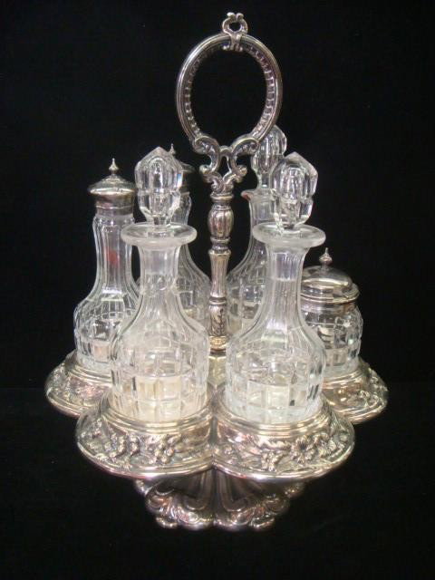Victorian Silver Plate and Glass Cruet Set:: Victorian Silver Plate and Glass Cruet Set: Silver Plate Lazy Susan Stand is 12 1/2"T and Holds Six Matching Polished Glass Cruets, 3 with Glass Stoppers and 3 with Silver Plate Tops. One Cruet Repair