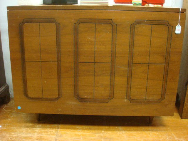 1950's Teak Fold Out Sewing Table: 1950's Teak Fold Out Sewing Table: 37"L X 14"W X 28"T. Has Line Carved Front with Folding Legs that Lifts to Table. Doors on Ends with Machine Shelf on Right and Notions Compartment on Left. (100-200)