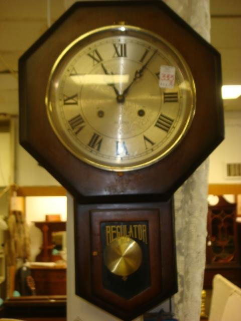 ALARON 31 Day Regulator Wall Clock: ALARON 31 Day Regulator Wall Clock: Metal Face with Roman Numerals and Black Spade Hands. Glass Door to View Pendulum. 22"L. (30-50)