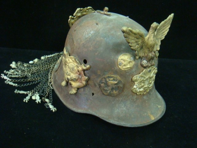 TRENCH ART "COMPANY FOOL HELMET" World War I Era:: TRENCH ART "COMPANY FOOL HELMET" World War I Era: Given to the Individual who did the Dumbest Stunts of the Day. World War One Era German Coal Shuttle Helmet Decorated with Medallions and Eagles. Chai