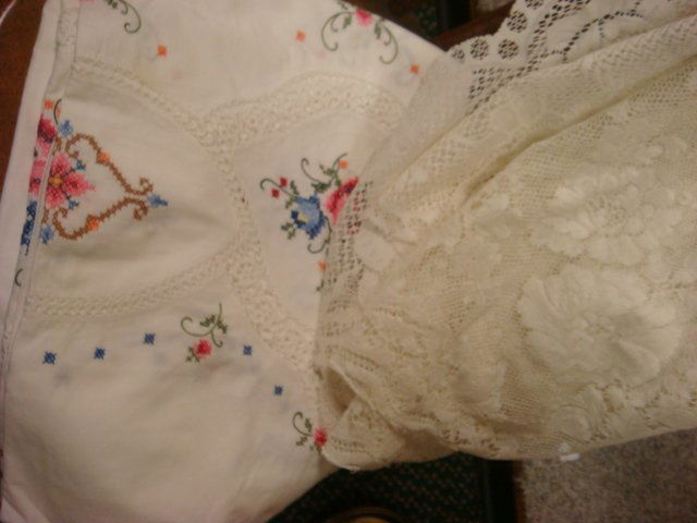 Three Lace and Hand Cross Stitched Table Clothes: Three Lace and Hand Cross Stitched Table Clothes: Scalloped Edge Cloth with Basket is 90" X 64", Second Lace Cloth is 92" X 72". White Cloth with Inset Lace and Cross Stitch Floral is 8' X 66". Some S