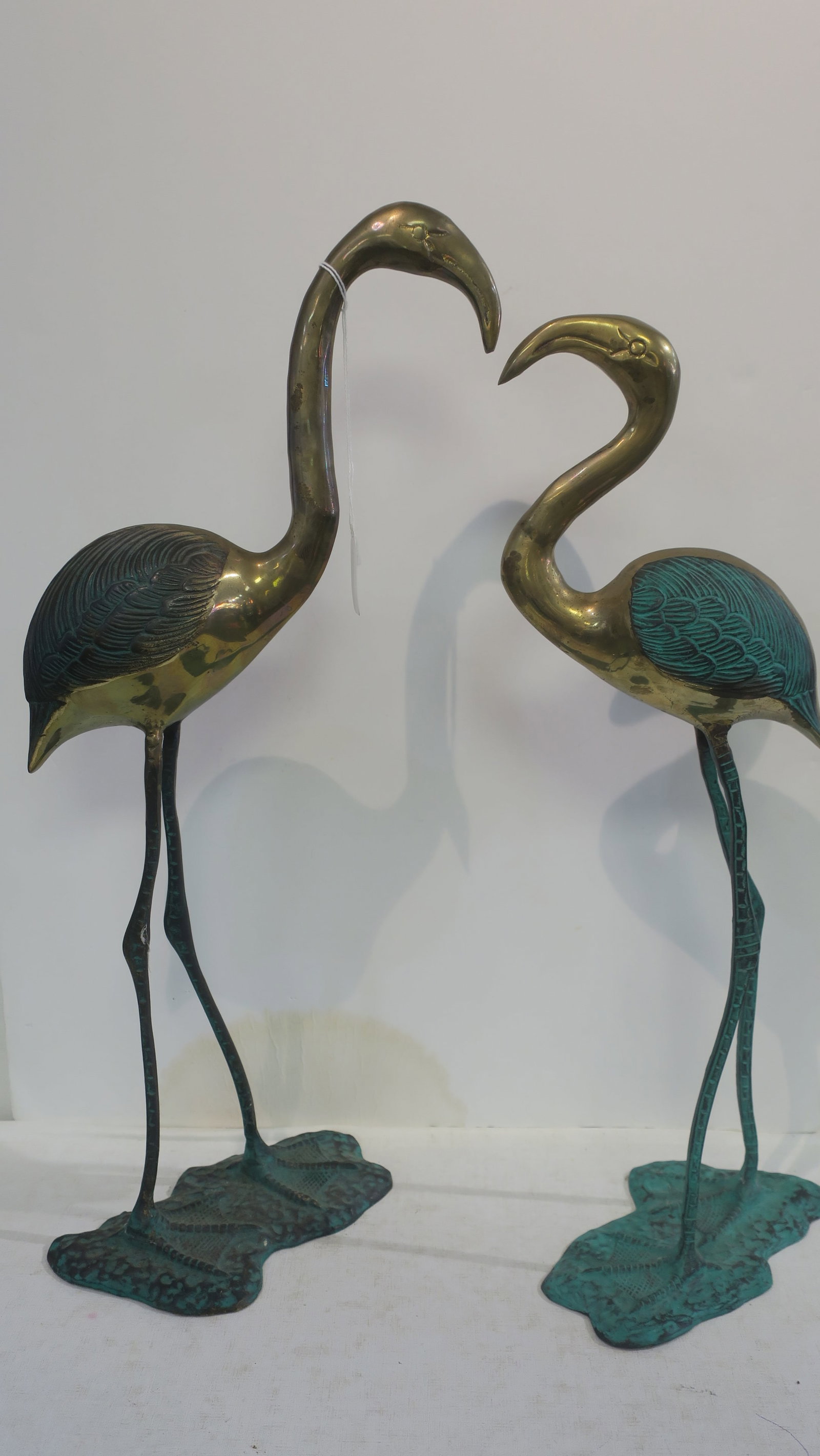 Two Brass Flamingos Garden Statuary:: Two Brass Flamingos Garden Statuary: Verdigris Patina on Wings and Legs of Slender Free Standing Birds. Etched Plumage and Detailed Features. Fixed on Irregular Shaped base. 19" and 21"T. (100-200)