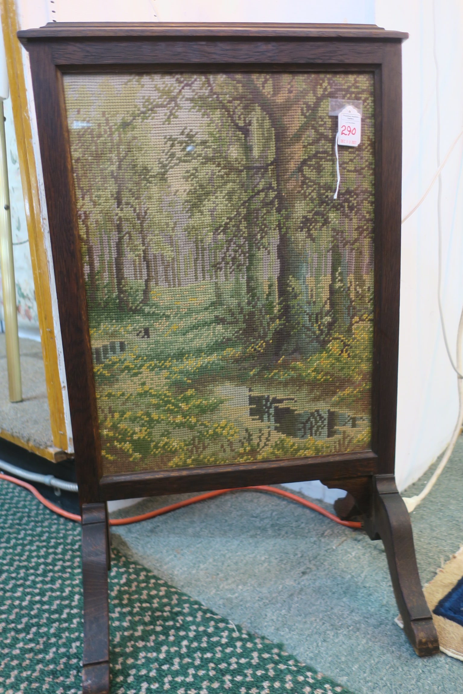 Handmade Needlepoint Fire Screen:: Handmade Needlepoint Fire Screen: Forest and Stream in Greens and Browns. Dark Oak Frame with 4 Curving Legs. 29"T, 17"W, 14"D. (50-100)