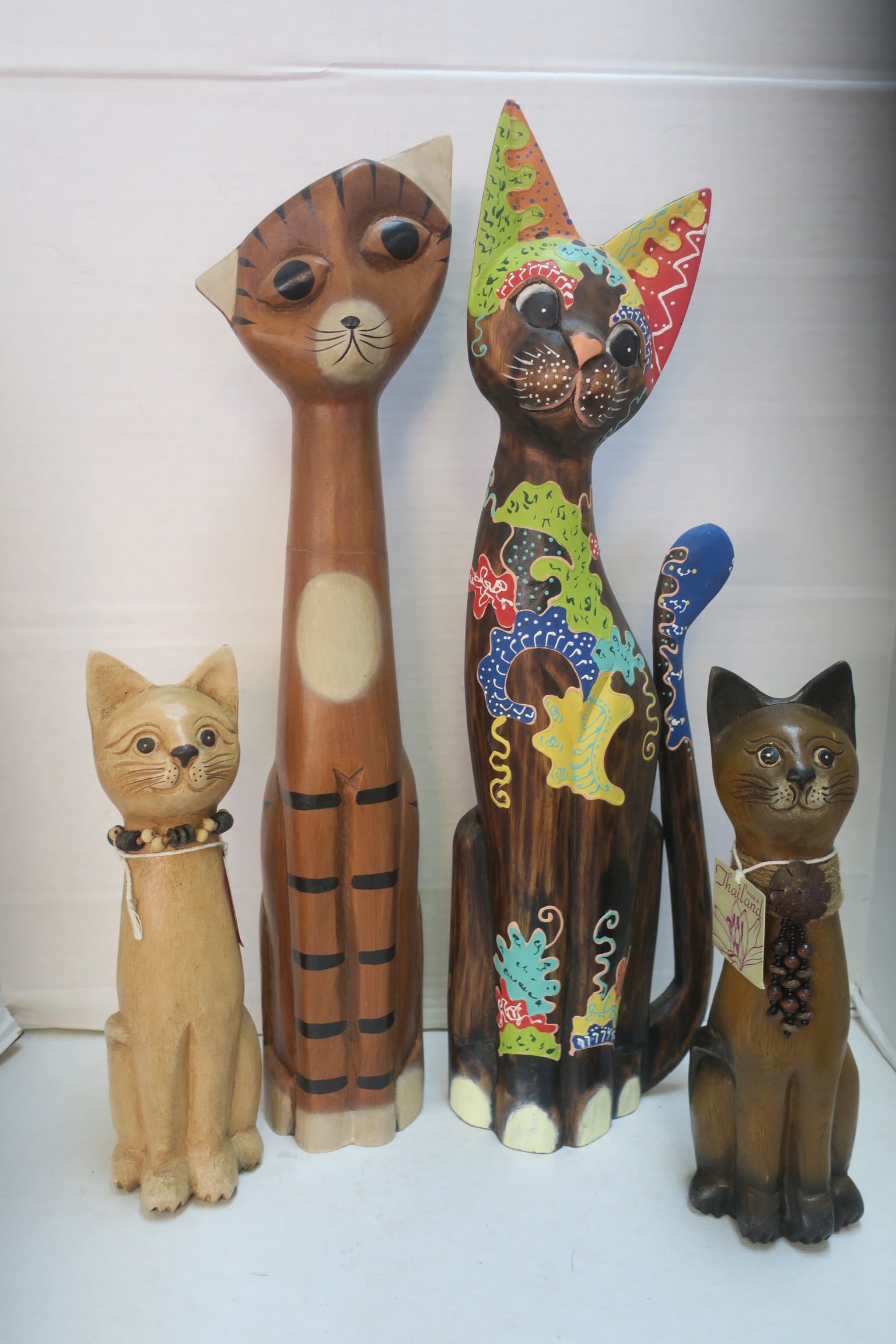 Four Hand Carved and Painted Wooden Cats:: Four Hand Carved and Painted Wooden Cats: One 23"T, Flat Back Balinese Cat, Solid 22 3/4"T Cat and Two 12"T Cats from Thailand with Beads. (100-200)