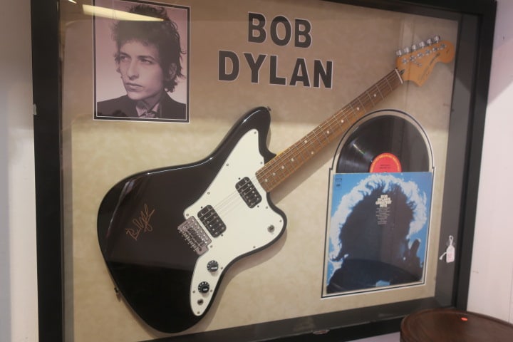 Montage of Signed BOB DYLAN Guitar, Photo and Record Album:: All in Shadowbox Frame. 6 String Squire Jagmaster Standard Duncan Design Electric Fender Guitar, Signed by Bob Dylan. Record and Award Winning Cover of 1967 Columbia Records Greatest Hits and Photogra