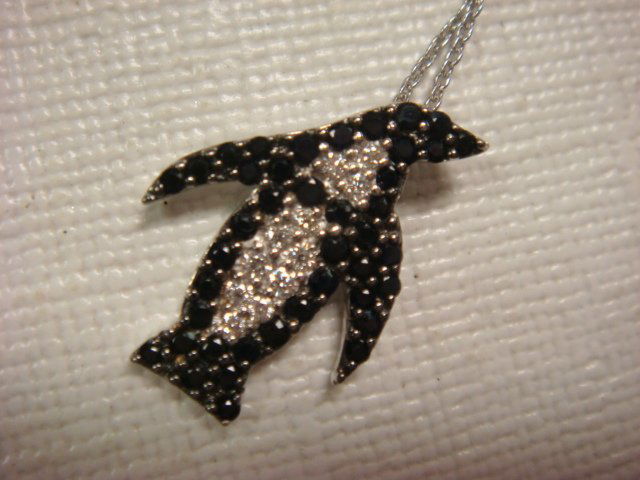 ROBERTO COIN 18KT Diamond, Black Sapphire Necklace: ROBERTO COIN 18KT Diamond, Black Sapphire Necklace: Penguin From the Tiny Treasure Collection. On 18KT White Gold Cable Chain. .08CT Diamonds, .40CT Sapphires. 17mm Long. In Original Box. With Signatu
