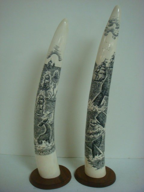 Pair of Signed Scrimshaw Decorated Walrus Tusks:: Pair of Signed Scrimshaw Decorated Walrus Tusks: Signed Sensen and Mike at Bottom. Scratched in Tusk Washed with Black Ink. Masted Ships with Whalers and Icebergs. Each Sits on Oval Wooden Base. 16" a
