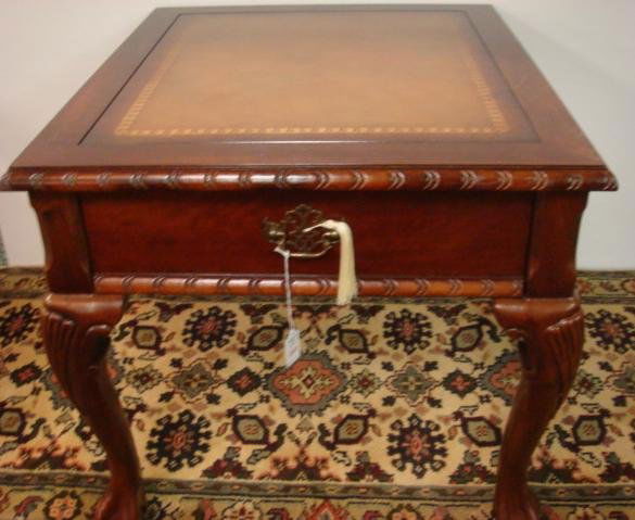 20th C. Leather Top End Table:: 20th C. Leather Top End Table: Gold Embossing or Stenciling on Brown Leather Top. Single Front Drawer. Raised on Gently Curving Legs with Shell Carved Knees. Claw and Ball Feet. 22"T X 24" W X 28"D. (