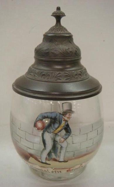 Vintage German Glass Stein with Enameled Bowler:: Vintage German Glass Stein with Enameled Bowler: Round Stein with Pewter Lid and Thumblift has Enameled Bowler Against Brick Wall with German Phrase Below. 7 1/2"T. (200-300)