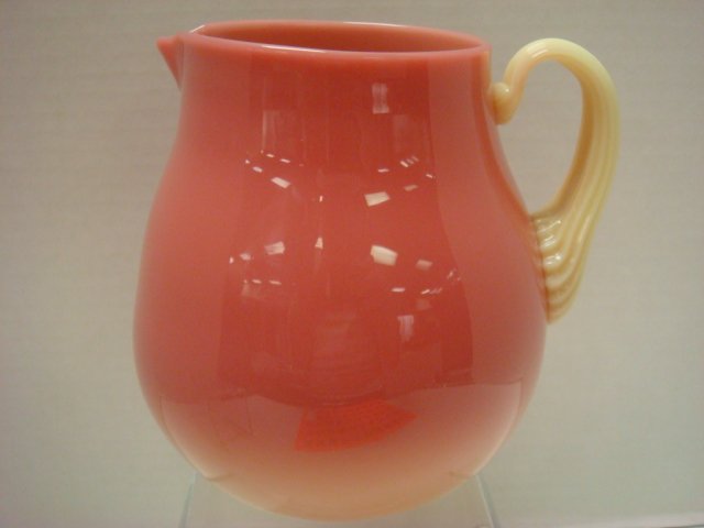 FENTON Gloss Finished Burmese Pitcher:: FENTON Gloss Finished Burmese Pitcher: Shading From Peach to Yellow with Applied Reeded Yellow Handle. Etch Signed Intaglio, 1994. From the Rindge Collection. 6"T. (80-120)