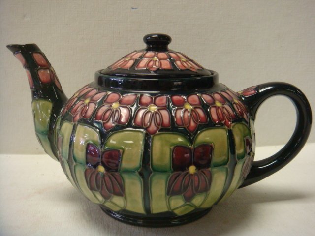 MOORCROFT "Violet" Teapot:: MOORCROFT "Violet" Teapot: Designed by Sally Tuffin, CA 1987-1990. Tube-Lined Design on Midnight Blue Ground with Bands of Stylized Violets. WM Monogram of William Moorcroft with Silver Line and PN on