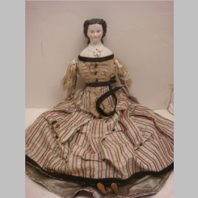 MARY TODD LINCOLN China Head Doll: With Snood,: MARY TODD LINCOLN China Head Doll: With Snood, With Snood, Porcelain Limbs, Cloth Body, Original Clothing. Parian Finish (repair to shoulderplate). 14"T (100-200)