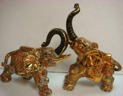 Two Enamel & Gold Over Ceramic Elephants:: Two Enamel & Gold Over Ceramic Elephants: Large Elephants W/Black Trunks, Gold Tusks, Ears & Saddles. Floral Designs are Displayed Encircling Its Body and Blanket. (80-100)