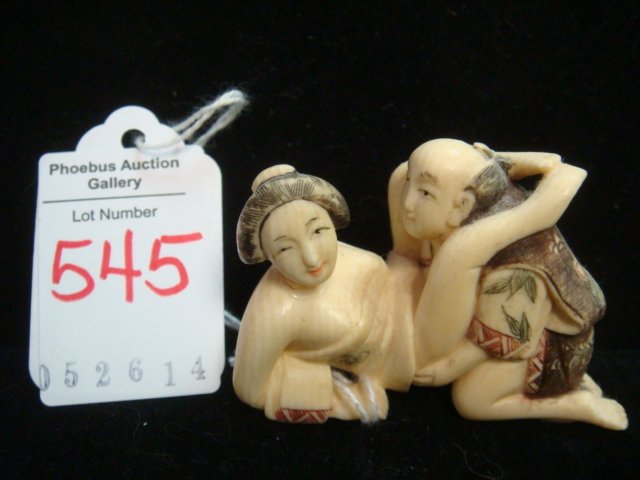 SIGNED CARVED IVORY EROTIC NETSUKE COUPLE:: SIGNED CARVED IVORY EROTIC NETSUKE COUPLE: Seductive Okimono Couple, 1 Piece, Signed Under Man's Foot. Inkstain Details on Incised Carved Robes and Hair. Kneeling Man & Reclining Woman in Amorous Posi