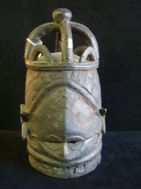 BUNDU Helmet Coming of Age Mask, Mende Tribe:: BUNDU Helmet Coming of Age Mask, Mende Tribe: Hand Carved From Sierra Leone, 15"T. Carved By Men, Worn by Women, Holes Around Neck for Raffia Collar, Darkened Interior. Cracked Down Forehead & Lower B