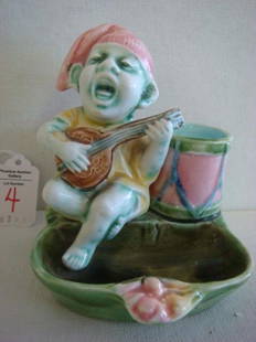 19th C Majolica Troubadour Match Holder/Striker:: 19th C Majolica Troubadour Match Holder/Striker: Man in Stocking Cap is Singing and Playing a Lute. "Drum" Holds Matches with Dish for Used Matches. Striker on Side. Incised 72 46 86 on Front. 4