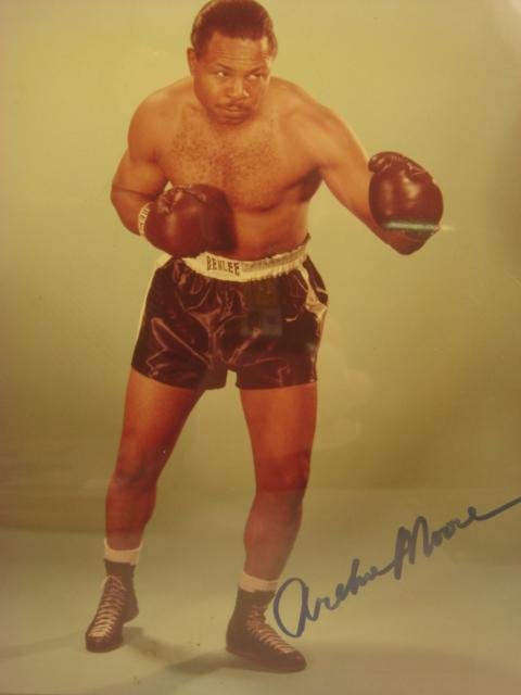 Autographed ARCHIE MOORE Photograph:: Autographed ARCHIE MOORE Photograph: 1916-1998; Boxer & Trainer. Nicknamed "The Old Mongoose". Only Boxer To Have Career Span 4 Decades. Color 8 X 10 Glossy Signed Photo in Blue Marker. COA by Memory 