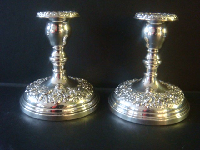 Pair of S KIRK & SON Sterling Repousse Candlesticks:: Pair of S KIRK & SON Sterling Repousse Candlesticks: Candlesticks are 4 3/4"T with Weighted Bases. Repousse Flowers Around Base and Top. Dent on Edge of One. (260-300)