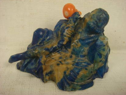 Lapis Lazuli And Coral Stopper Snuff Bottle:: Lapis Lazuli And Coral Stopper Snuff Bottle: Intricately Carved & Enrobed Happy Little Fella Is Smiling and Sitting Carrying A Staff In His Right Hand w/The Coral Stopper Atop. His Left Hand Appears