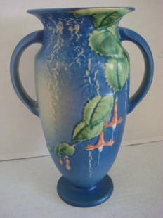 ROSEVILLE "Fuschia" Double Handled Blue Vase:: ROSEVILLE "Fuschia" Double Handled Blue Vase: Impressed Roseville 899-9". Blue Ground with Relief Green Leaves and Pink Flower. Small Flake on Bottom of Foot. Ca 1939-1944. (200-300)