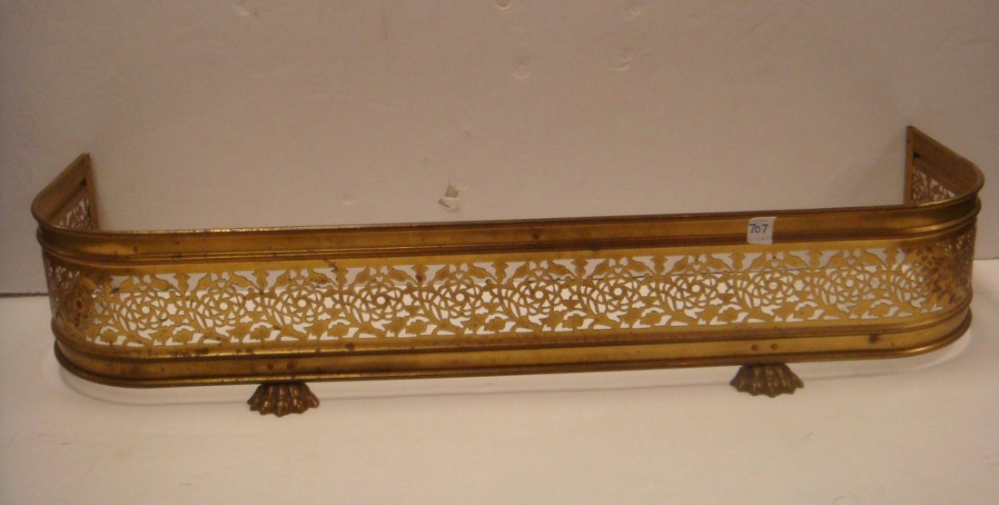 Pierced Brass Fireplace Fender:: Pierced Brass Fireplace Fender: Open Pierced Fretwork Design Above Ogee Shaped Base is Supported by 4 Cast Paw Feet. Ash Guard Hearth Rail with Curved Corners is 41"L X 8"T. Some Oxidation. (100-200)