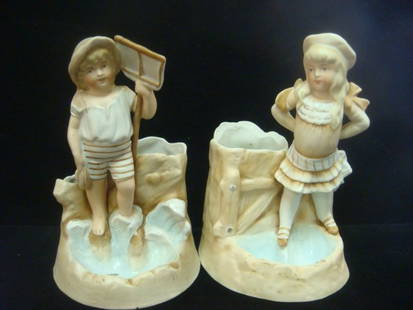 Two German Bisque Hand Painted Spill Vases: Boy and: Two German Bisque Hand Painted Spill Vases: Boy and Girl at Beach. Boy is Holding a Shovel with Waves and Fish at His Feet. 7 1/2"T. Girl is Standing by Holes in Sand. 7 3/4"T. Two Open Vases Behind