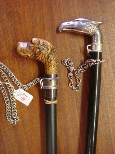 Two Metal Canes; Phoenix Sword Cane & Dog Head Cane:: Two Metal Canes; Phoenix Sword Cane & Dog Head Cane: Phoenix Bird Over 17" Sword in Cane with Metal Wrist Chain, 34" Tall. 32" Tall, Hound Dog Headed Cane with Heavy Link Wrist Chain. (100-200)