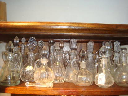 Collection of Pressed Glass Cruets:CA 1930: Collection of Pressed Glass Cruets, CA 1930: Twenty Plus Glass Cruets. Most Have Stoppers and Some Have Their Original Labels. Various Sizes. (50-75)