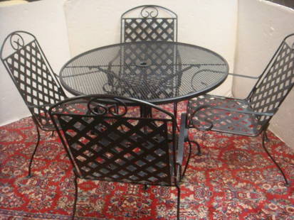 Round Black Wrought Iron Table with Four Chairs:: Round Black Wrought Iron Table with Four Chairs: Mesh Top with Insert for Umbrella at Center. Supported by Quad Legs. Four Wide Lattice Pattern Armchairs w/Scrolled Arms. Table Measures 25"T X